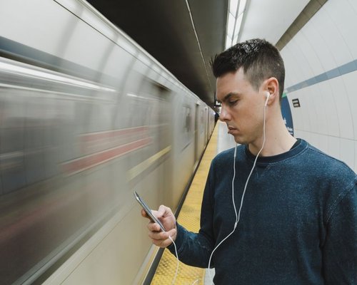 Man using a smartphone in a subway station